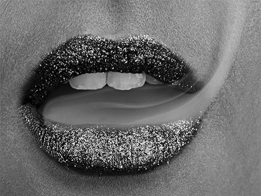 Black and white mouth half-open with glistening lips which exceed 2 or 3 beautiful white teeth. From this mouth came a cigarette fumed flying up